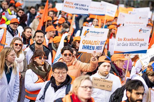 Menschen nehmen an einer Demonstration von Uniklinik-Ärzten auf dem Opernplatz in Hannover teil.