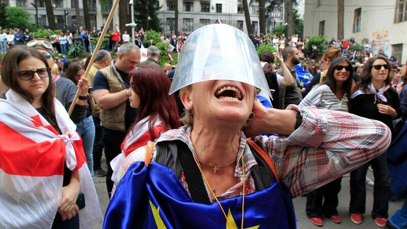 EU legt Beitrittsprozess von Georgien vorerst auf Eis Menschen protestieren vor dem Parlamentsgebäude in Tiflis gegen das Gesetz über ausländische Einflussnahme.