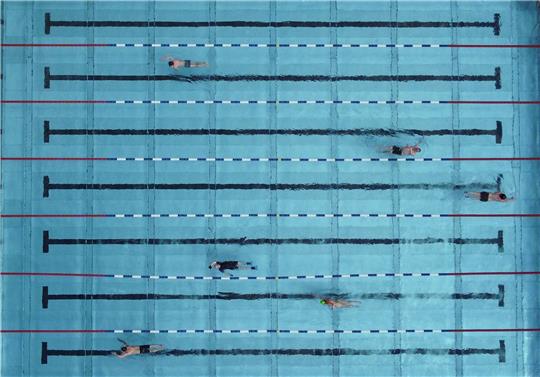 Menschen schwimmen in einem Freibad.