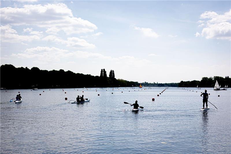 Menschen sind am Vatertag bei sonnigem Wetter mit Kanu, Stand-up-Paddle-Board und Booten auf dem Maschsee unterwegs.