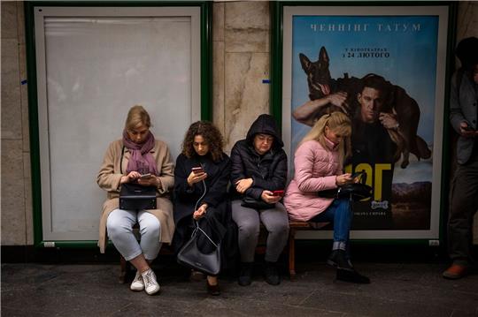 Menschen sitzen in einer U-Bahn-Station in Kiew. Die Station dient als Luftschutzbunker.
