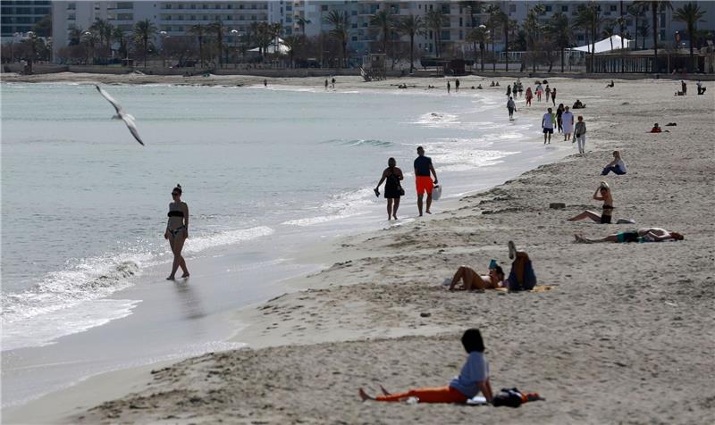 30 Grad und mehr an Spaniens Mittelmeerküste Menschen sonnen sich am Strand von Cala Millor auf Mallorca.