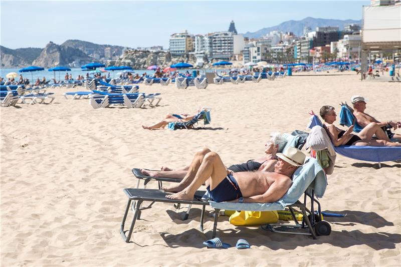 Temperaturrekorde - Spanien stöhnt unter Winterhitze Menschen sonnen sich am Strand von Poniente in Spanien.