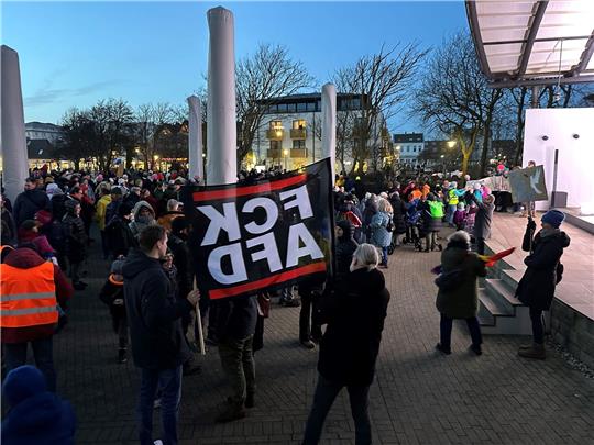 Menschen stehen bei einer Kundgebung bei einer Demonstration gegen rechts.