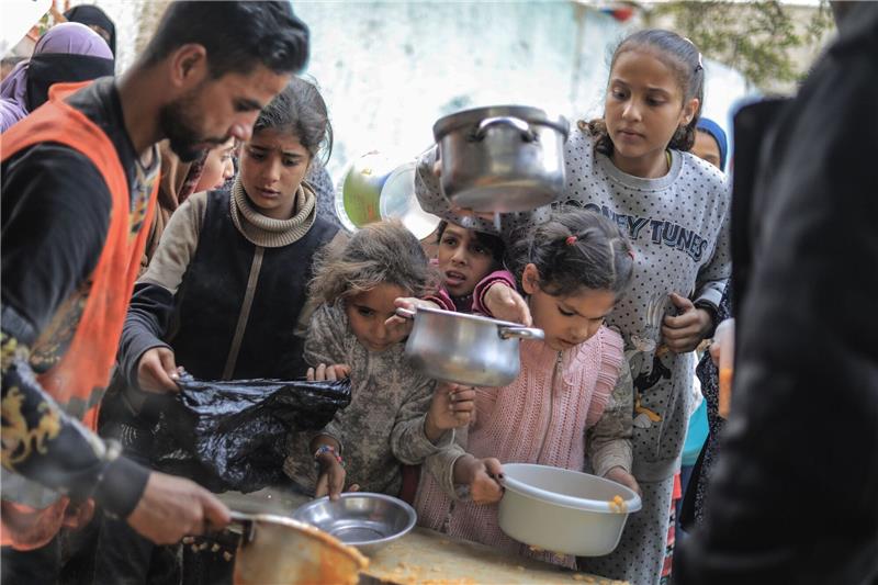 Not in Gaza verschärft sich - USA lehnen Waffenstillstand ab Menschen stehen in Rafah im Süden des Gazastreifens mit Töpfen, Schalen und Tüten bei einer Essensausgabe an.