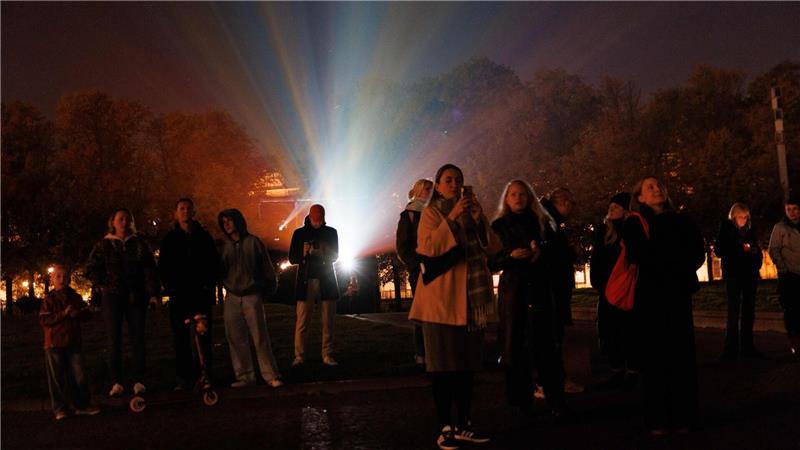 Bilder des Tages Menschen stehen vor einem Beamer, während der Berliner Dom bei der Generalprobe für das 21. Festival of Lights Berlin unter dem Motto „Let’s Shine Together“ angestrahlt wird.