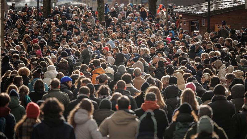 Menschen stehen zusammen während einer Schweigeminute bei der Trauerfeier für die Opfer des verheerenden Brandes in Crans-Montana in der Schweiz.