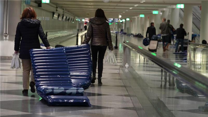 Menschen tragen nach möglichen Drohnensichtungen am Flughafen München Luftmatratzen. 