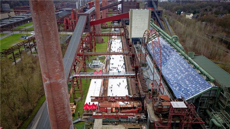 Menschen tummeln sich auf der Eisbahn in der Zeche Zollverein in Essen. 