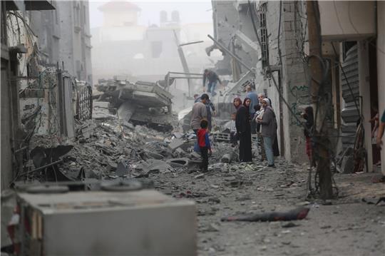 Menschen versammeln sich auf den Trümmern eines zerstörten Gebäudes nach einem Luftangriff im Flüchtlingslager Maghazi im Zentrum des Gazastreifens.