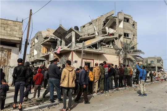 Menschen versammeln sich nach einem israelischen Luftangriff in Rafah um das zerstörte Haus einer Familie.