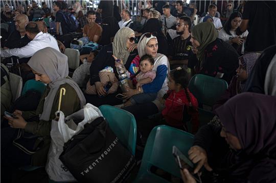 Menschen warten am Grenzübergang zwischen dem Gazastreifen und Ägypten.