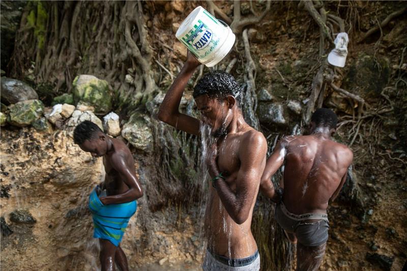 Knapp drei Dutzend Cholera-Tote im Krisenstaat Haiti Menschen waschen sich in einer Schlucht in Port-Au-Prince.