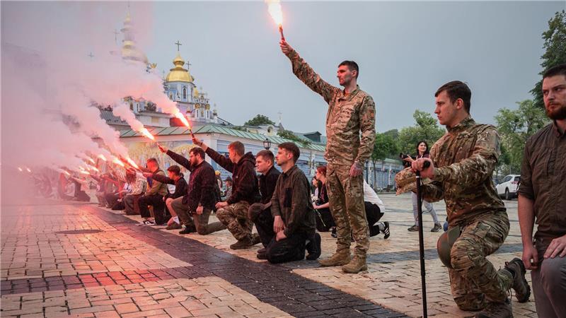 Menschen zünden Fackeln während der Beerdigungszeremonie für einen gefallenen ukrainischen Soldaten in Kiew.