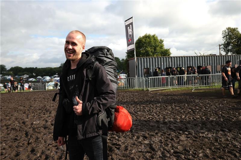 Metalfans feiern in Wacken, aber nicht alle dürfen rein Metal-Fan Christian aus Husum vor dem Haupteingang zu dem vom Regen aufgeweichten Festivalgelände.