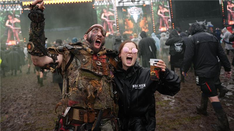 Bilder des Tages Metalfans feiern nach der Öffnung des sogenannten „Infield“ vor den beiden Hauptbühnen auf dem Festivalgelände des Wacken Open Airs.