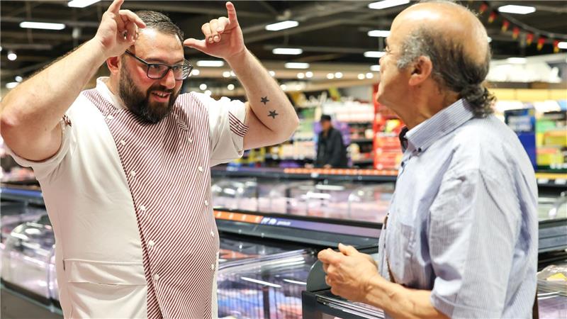 Metzger Yevgeniy Klibanov zeigt die Gebärde für „Rind“. 