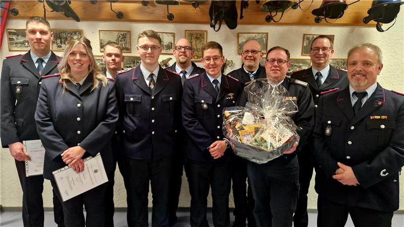 Gruppenfoto mit zehn Feuerwehrleuten. Michael Habekost erhält zu seinem Abschied einen Präsentkorb. Der neue Ortsbrandmeister Martin Urlaub (r.) und Stadtbrandmeister Markus Finck (2.v.r.) befördern und ehren die Wildemanner Feuerwehrleute. 