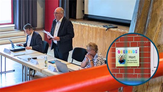 Eine Ratssitzung in einem Saal, bei der ein Mann an einem Konferenztisch steht und Unterlagen vorliest, während zwei weitere Personen am Tisch sitzen. Rechts ist ein kreisförmiger Ausschnitt eingefügt, der ein Schild mit der Aufschrift „OKERKIDS Hort der Gemeinde Schladen-Werla“ an einer roten Backsteinmauer zeigt.