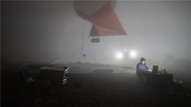 Forschung extrem: Schwarzlicht-Frösche und eisige Einsamkeit Michael Lonardi mit einem Wetterballon in dichtem Nebel auf dem Berg Helmos in Griechenland.