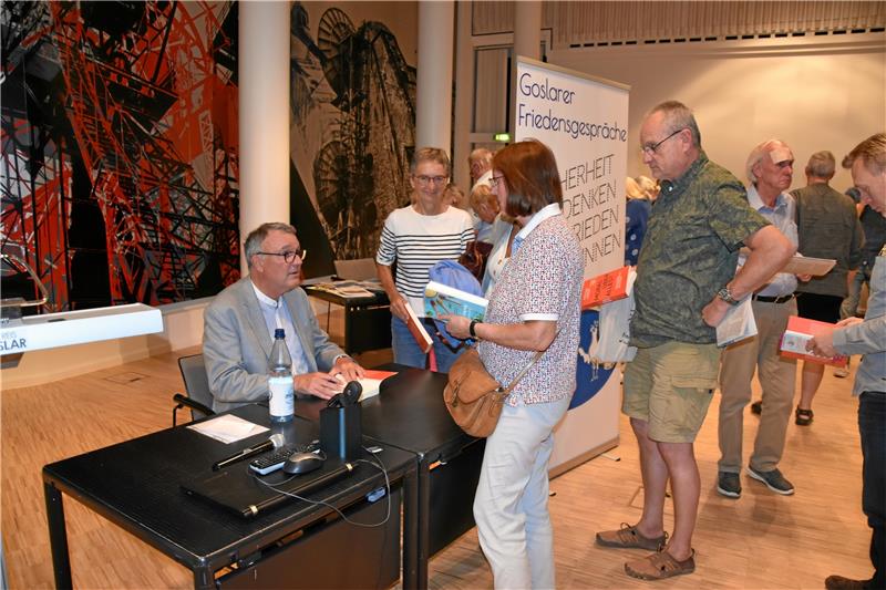 Michael Lüders spricht beim Friedensbündnis über Ukraine Michael Lüders (links) signierte nach dem Vortrag zahlreiche Bücher für die Zuhörer. Foto: Hartmann