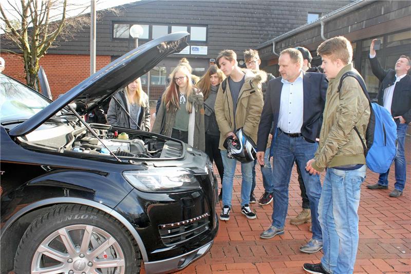 Michael Neuse (3. v. re.) zeigt den Audi Q 7 für rund 300.000 Euro. So einer parkt nicht jeden Tag vor der Schule.  Fotos: Stumpf