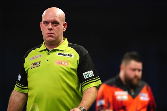 Michael van Gerwen (l) reagiert vor Michael Smith.