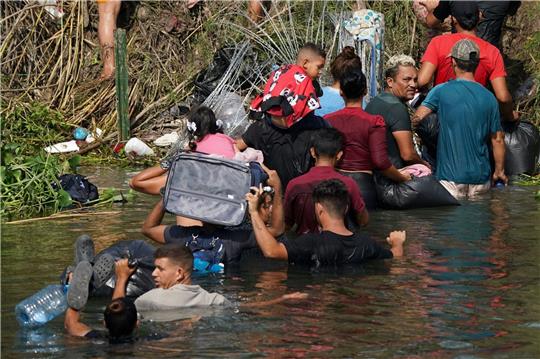 Migranten durchqueren den Grenzfluss Rio Grande zwischen Mexiko und den USA.