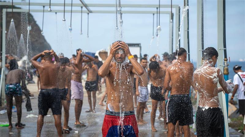 Migranten duschen in einer Anlage am Strand von El Trampolín in der spanischen Exklave Ceuta, wo zahlreiche provisorische Unterkünfte errichtet wurden.