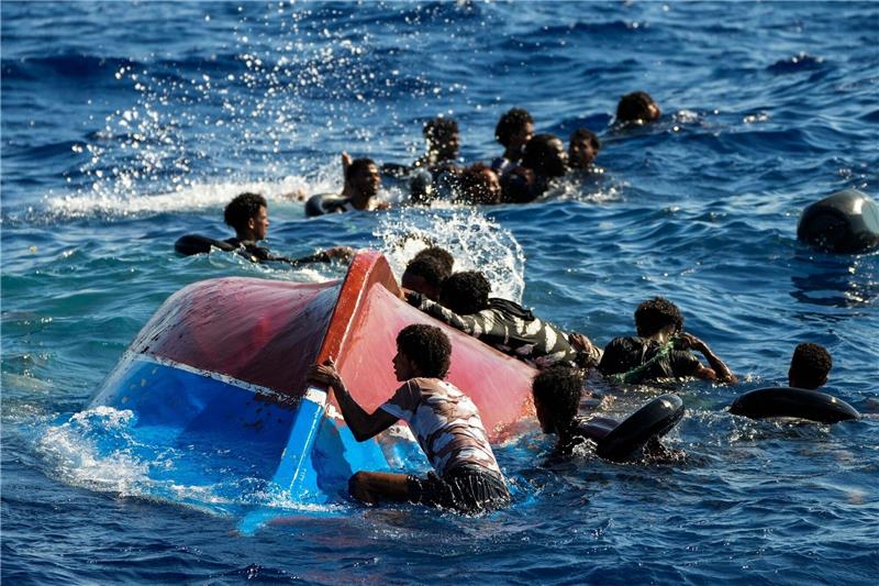 Küstenwache Italiens: Vier Migranten im Mittelmeer gestorben Migranten schwimmen neben ihrem umgestürzten Holzboot im Mittelmeer (Archiv).