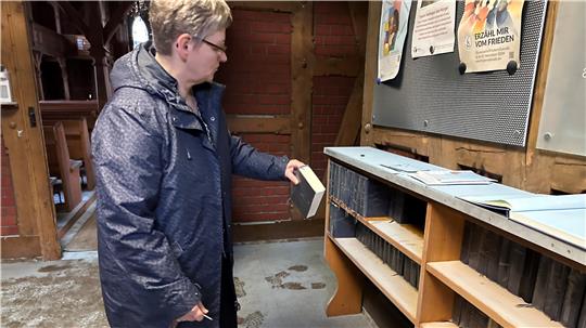 Millimeter dick liegt das weiße Pulver aus dem Feuerlöscher im gesamten Kirchenschiff verteilt. Im Vorraum sind das Gästebuch und die Gesangbücher besonders beschädigt worden, wie Antje Speit vom Kirchenvorstand zeigt.