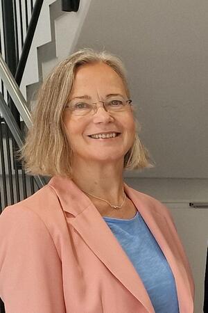 Abschied nach Jahrzehnten: Schule am Harly sagt Miriam Albers ade Eien Frau im creme-farbenen Blazer steht in einem Treppenhaus und lächelt.