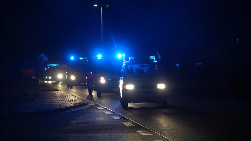 Das Bild zeigt einen nächtlichen Konvoi mehrerer Einsatzfahrzeuge auf einer Straße. Im Vordergrund fährt ein Einsatzfahrzeug mit eingeschaltetem blauen Blaulicht, dahinter folgen weitere Fahrzeuge mit eingeschalteter Warn- und Beleuchtungstechnik. Die Aufnahme entstand bei Dunkelheit an einer Kreuzung beziehungsweise Einmündung und vermittelt durch die Beleuchtung und die Fahrbewegung eine typische Einsatzfahrt.