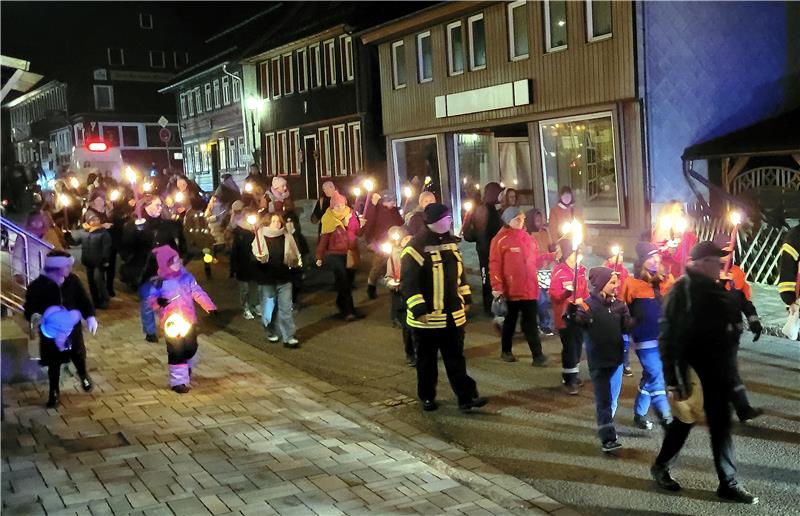 Mit Fackeln und Laternen erleuchten Kinder und Erwachsene die Straßen.