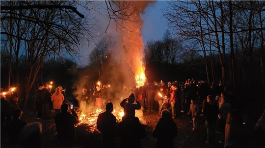 Mit Fackeln und aus der Glut eines kleineren Feuers wird 2024 die mit Strauchschnitt ummantelte Fichte am Ottiliae-Schacht entzündet.