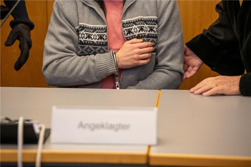 Brandanschlag auf Synagoge - Geständnis beim Psychiater Mit Handschellen gefesselt sitzt ein Mann im Landgericht auf der Anklagebank.