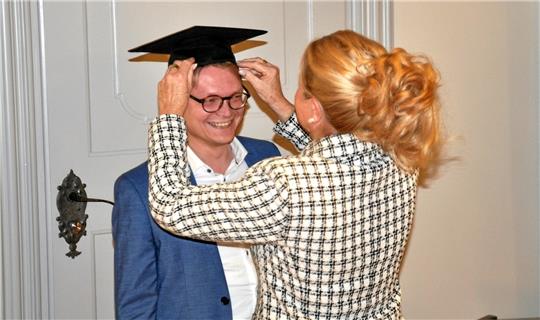Mit Köpfchen zum Doktor-Titel: Oberbürgermeisterin Urte Schwerdtner verpasst dem Sudmerberger Ratsherrn Pascal Bothe den standesgemäßen Kopfschmuck. Foto: Heine