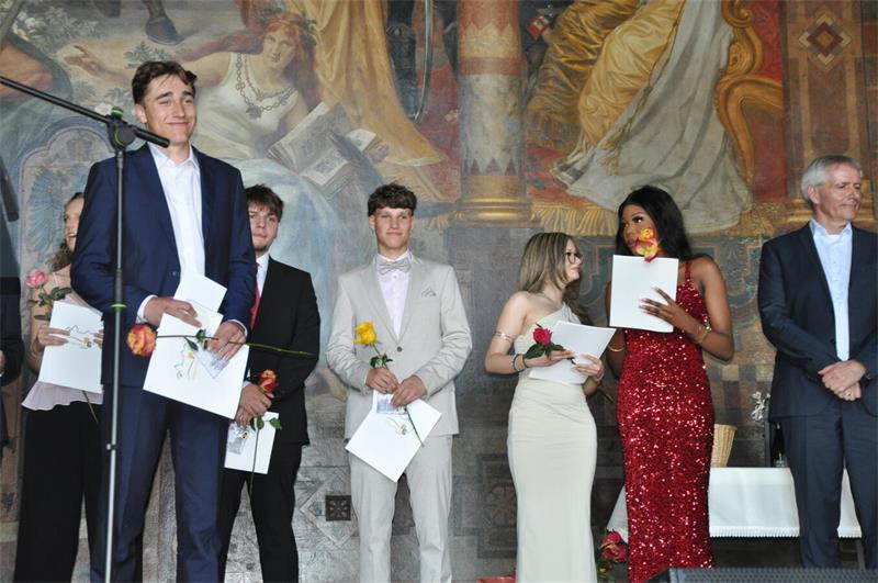 Mit Rose und Zeugnis stehen die Abiturienten auf der Kaiserpfalz-Bühne.