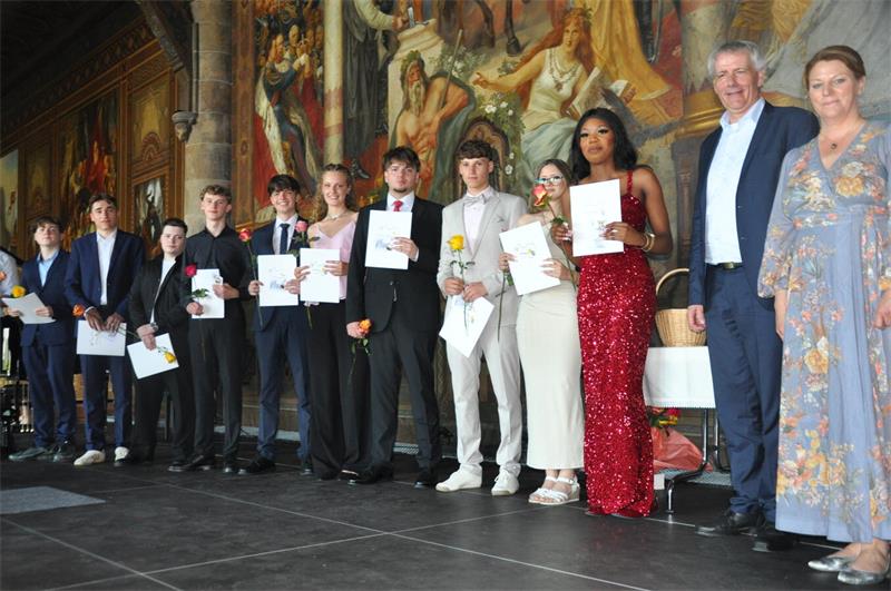 Mit Rose und Zeugnis stehen die Abiturienten auf der Kaiserpfalz-Bühne.