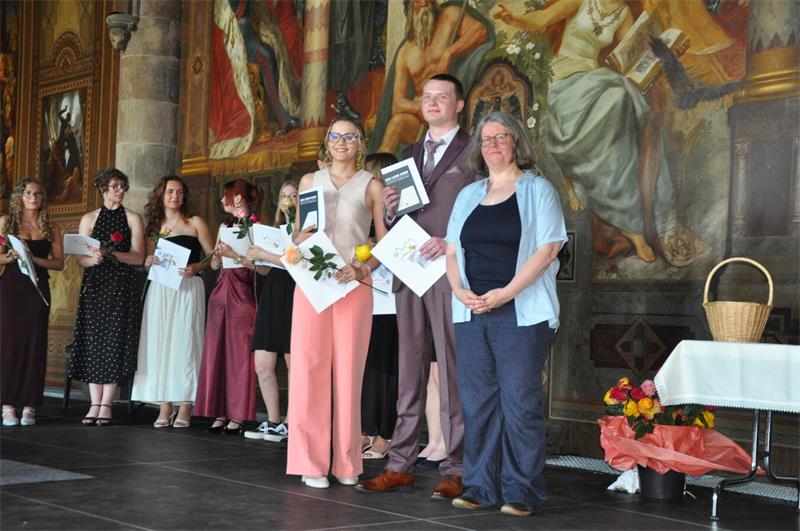 Mit Rose und Zeugnis stehen die Abiturienten auf der Kaiserpfalz-Bühne.
