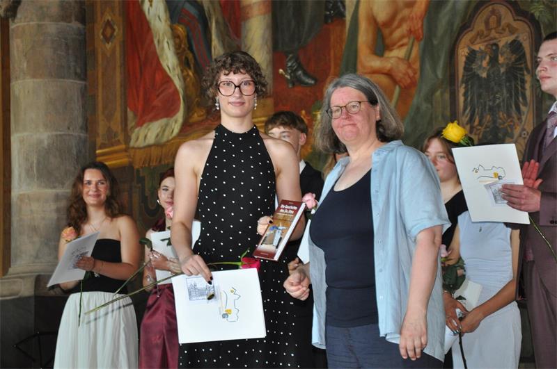Mit Rose und Zeugnis stehen die Abiturienten auf der Kaiserpfalz-Bühne.