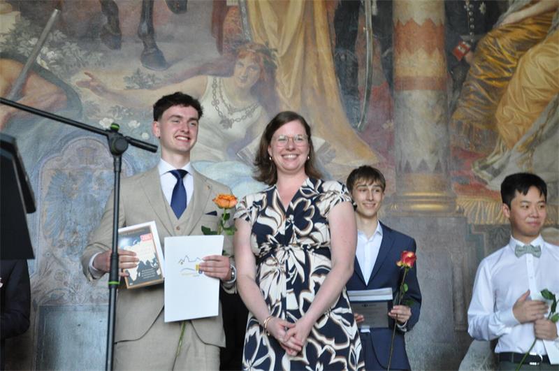 Mit Rose und Zeugnis stehen die Abiturienten auf der Kaiserpfalz-Bühne.