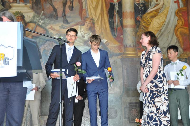Mit Rose und Zeugnis stehen die Abiturienten auf der Kaiserpfalz-Bühne.