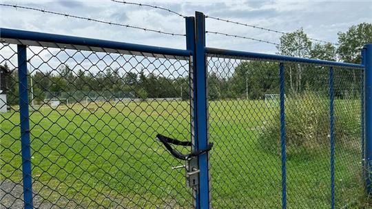 Mit Schloss und Stacheldraht ist der Zaun zu den Sportplätzen in Hohegeiß gesichert.