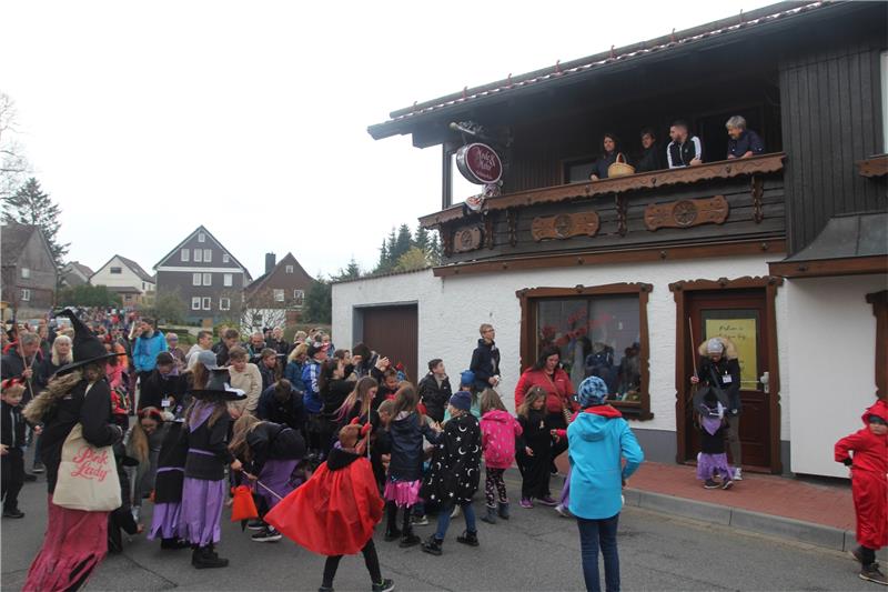 Hunderte feiern in Hohegeiß Walpurgis Mit Süßigkeiten sorgen die Hohegeißer von den Balkonen aus, dass der Festumzug durch das Bergdorf ins Stocken gerät. Die vielen kleinen Hexen und Teufel freuen sich.