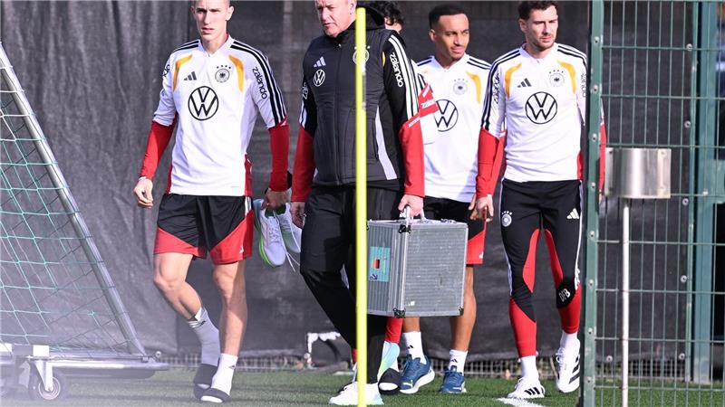 Mit Teamarzt Hahne (2.v.l.) betritt Schlotterbeck (l.) den Trainingsplatz. 