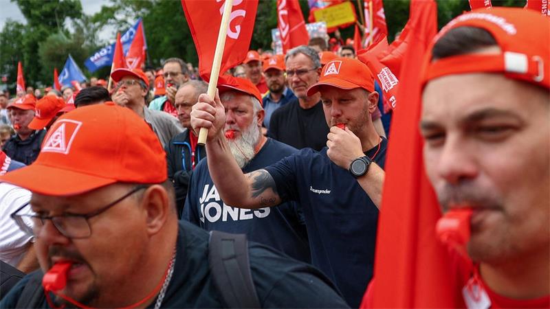 Mit Tröten und Trillerpfeifen macht Mitarbeiter ihrem Unmut Luft.
