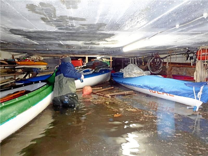 Mit Wathosen geschützt, bergen Clubmitglieder die Jugendboote im überfluteten Bootskeller des Clubhauses. Foto: Teicke