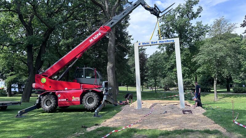 Bad Harzburgs neueste Attraktion steht im Kurpark Mit dem Autokran wird der Schaukelrahmen auf sein Fundament gestellt.