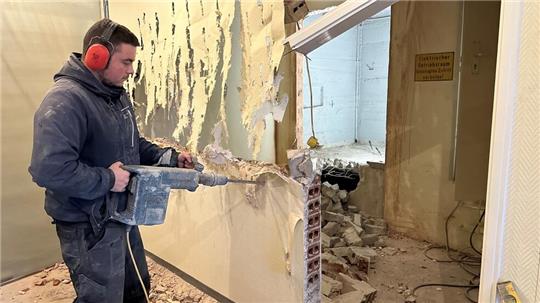 Mit dem Bohrhammer zerstören die Mitarbeiter von „Beton Stein“ die Wand im dritten Stock des Rathauses, damit der neue Fahrstuhl eingebaut werden kann.